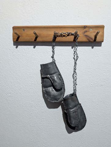 Gertrud Riethmüller, Visual Artist installation, video, sound, performances. Bleischwere Fürsorge, 2024, ein Paar Kinderfäustlinge, genäht aus Walzblei.
